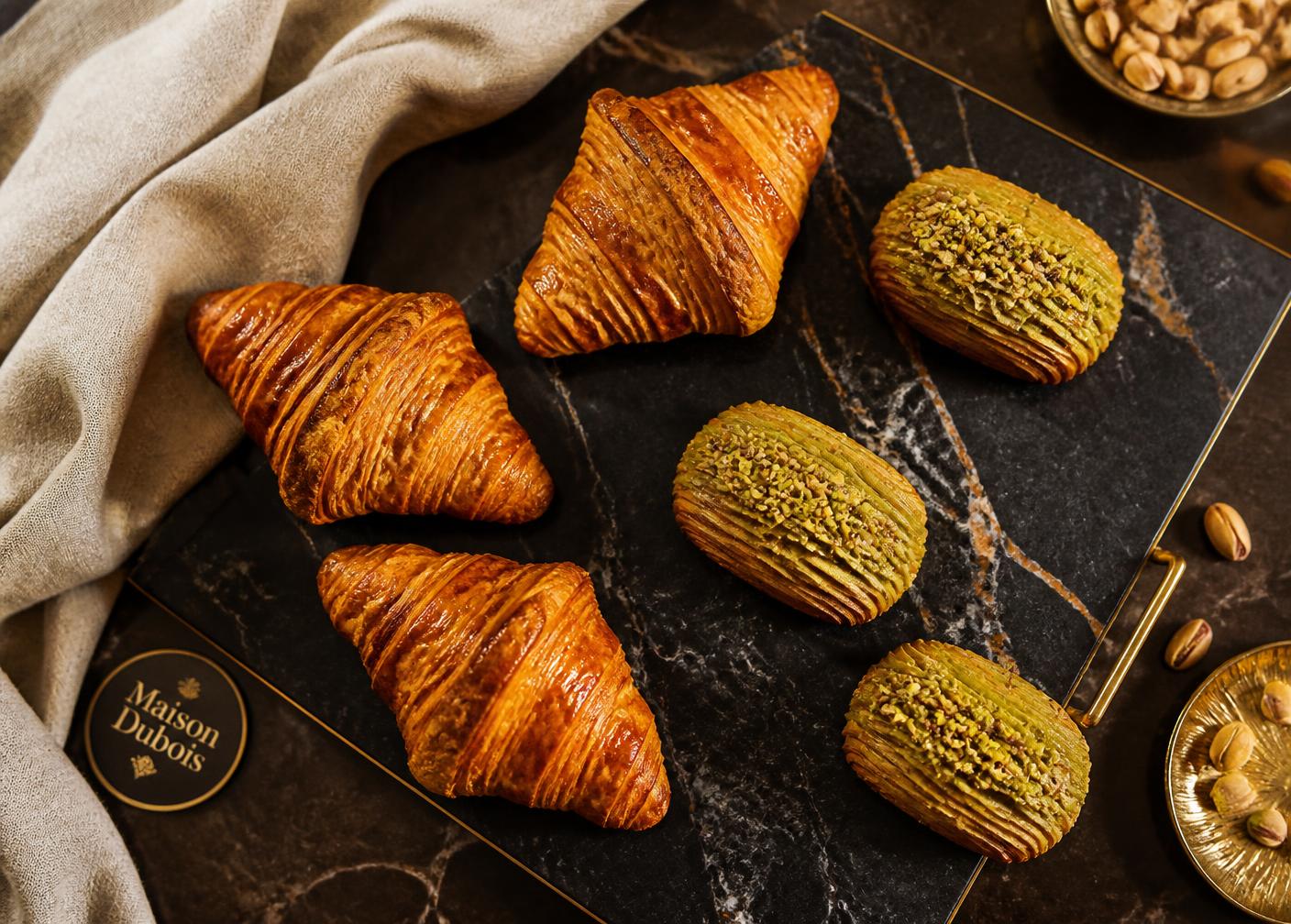 Croissants and pistachio escargots on dark marble